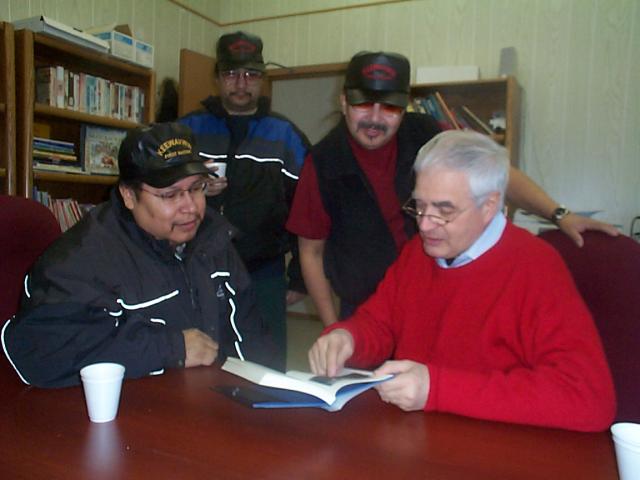 Keewaywin Councillor David Thompson looking on as His Honourale James K. Bartleman looks through the book which he donated to th